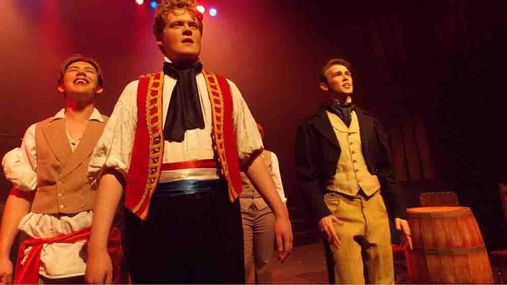 Three male students in costume singing