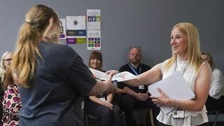 Gillian Taylor hands a certificate to a Childhoode Studies learner.