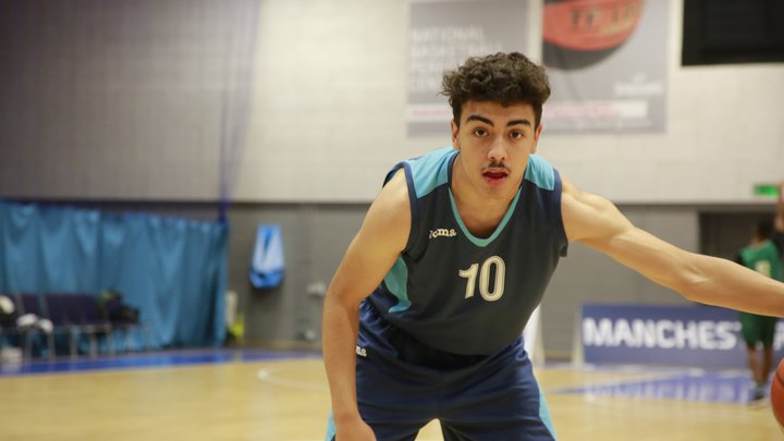 A young man moving towards the camera while playing basketball