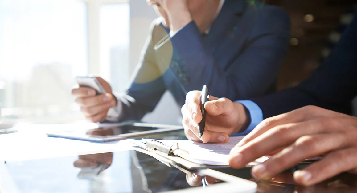 People reviewing documents during a business meeting.